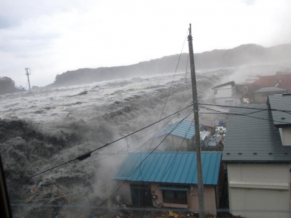 堤防を乗り越えて町に押し寄せる津波