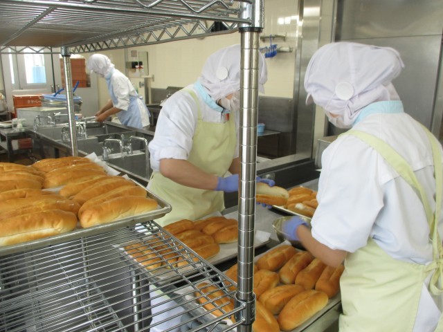 パンにガーリック豆乳バターを塗っています。